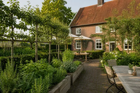 Kräuterbeete und Spalierobst liegen direkt neben der kleinen Terrasse.